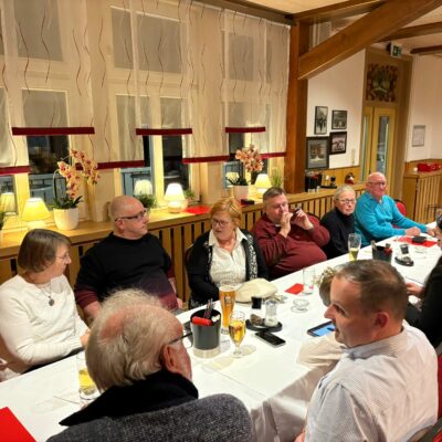 An einer langen Tafel sitzen viele Menschen